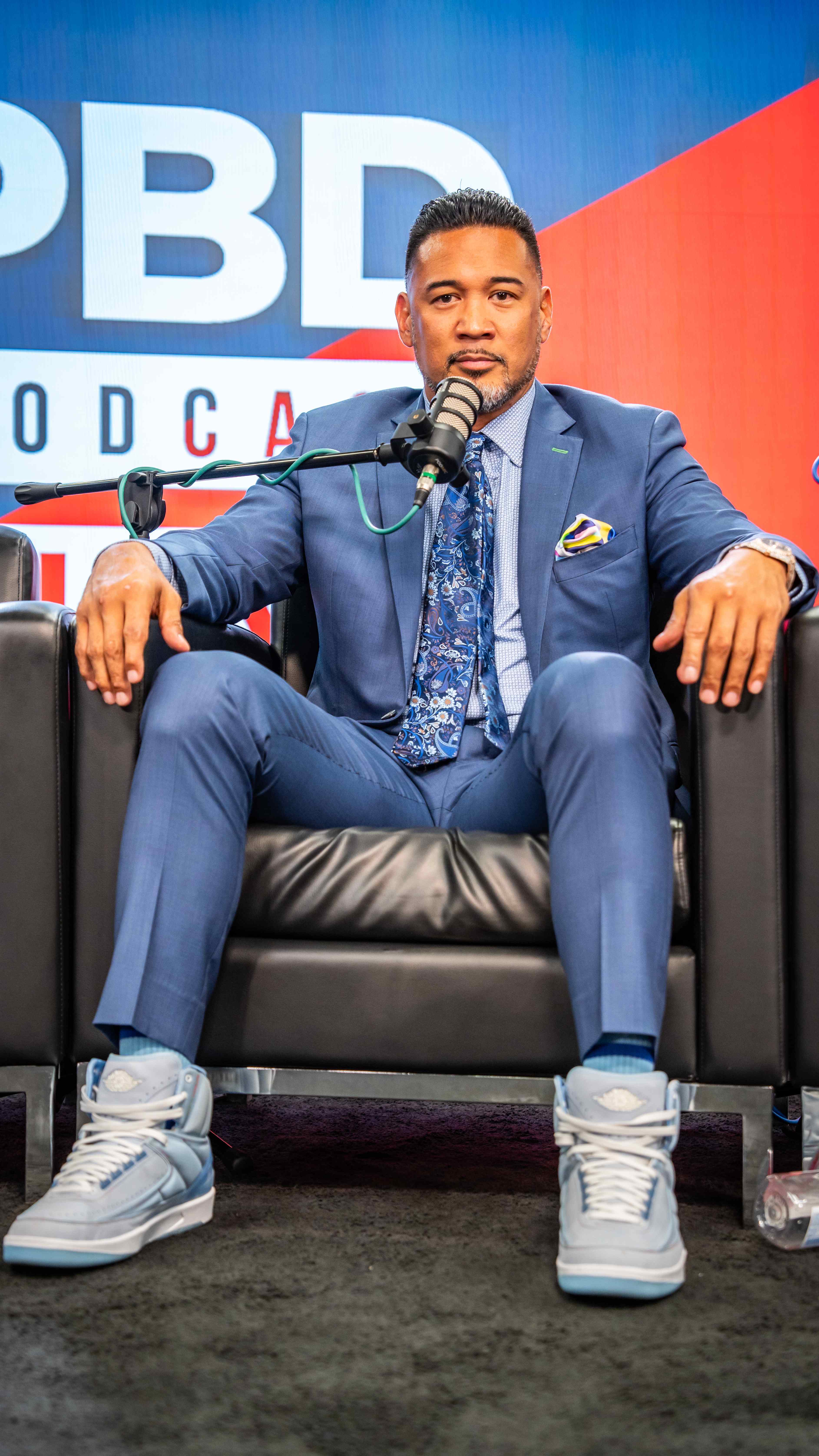 Podcast guest in blue suit at PBD Podcast studio