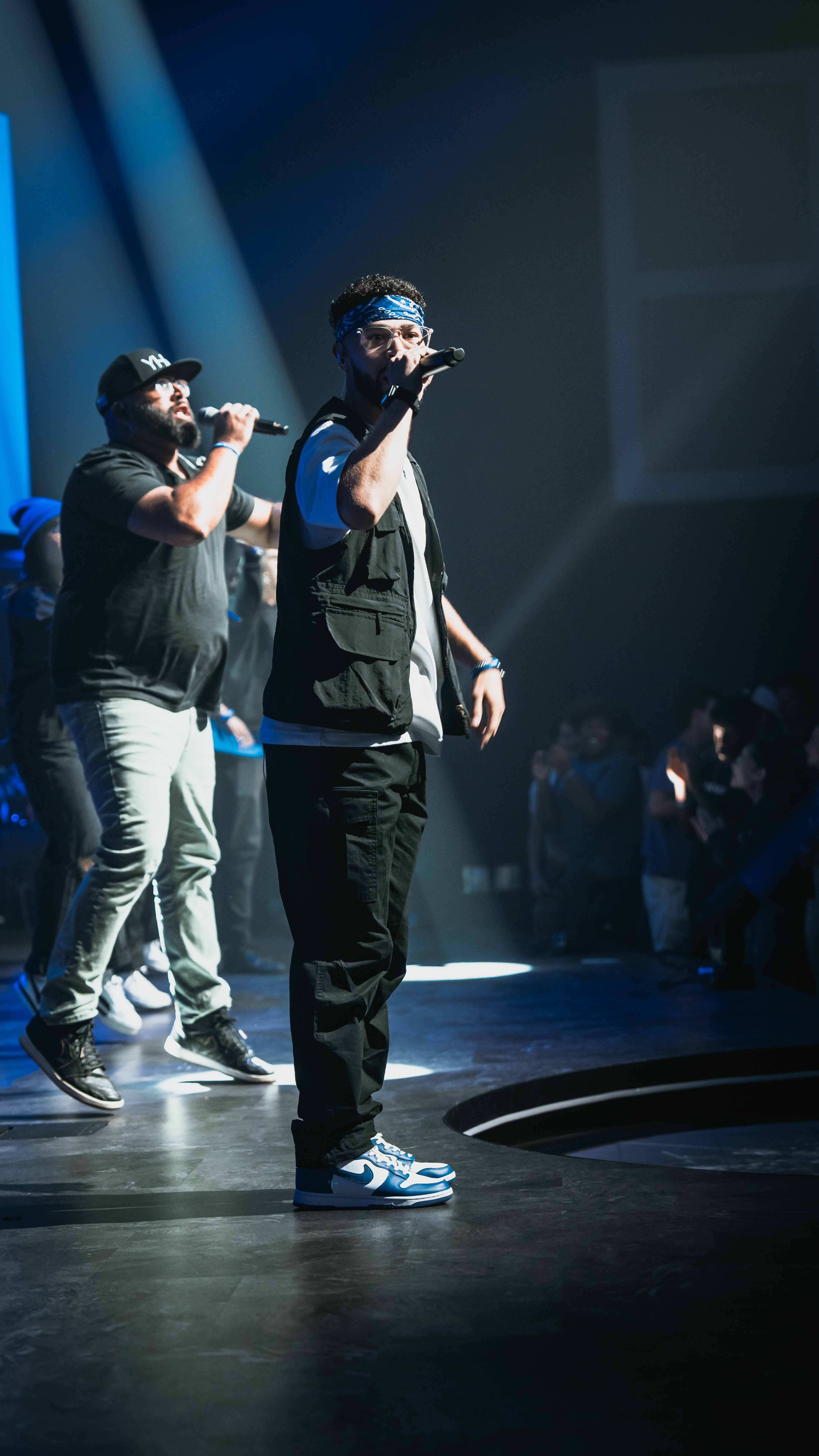 Two performers on stage under blue spotlight during ministry event