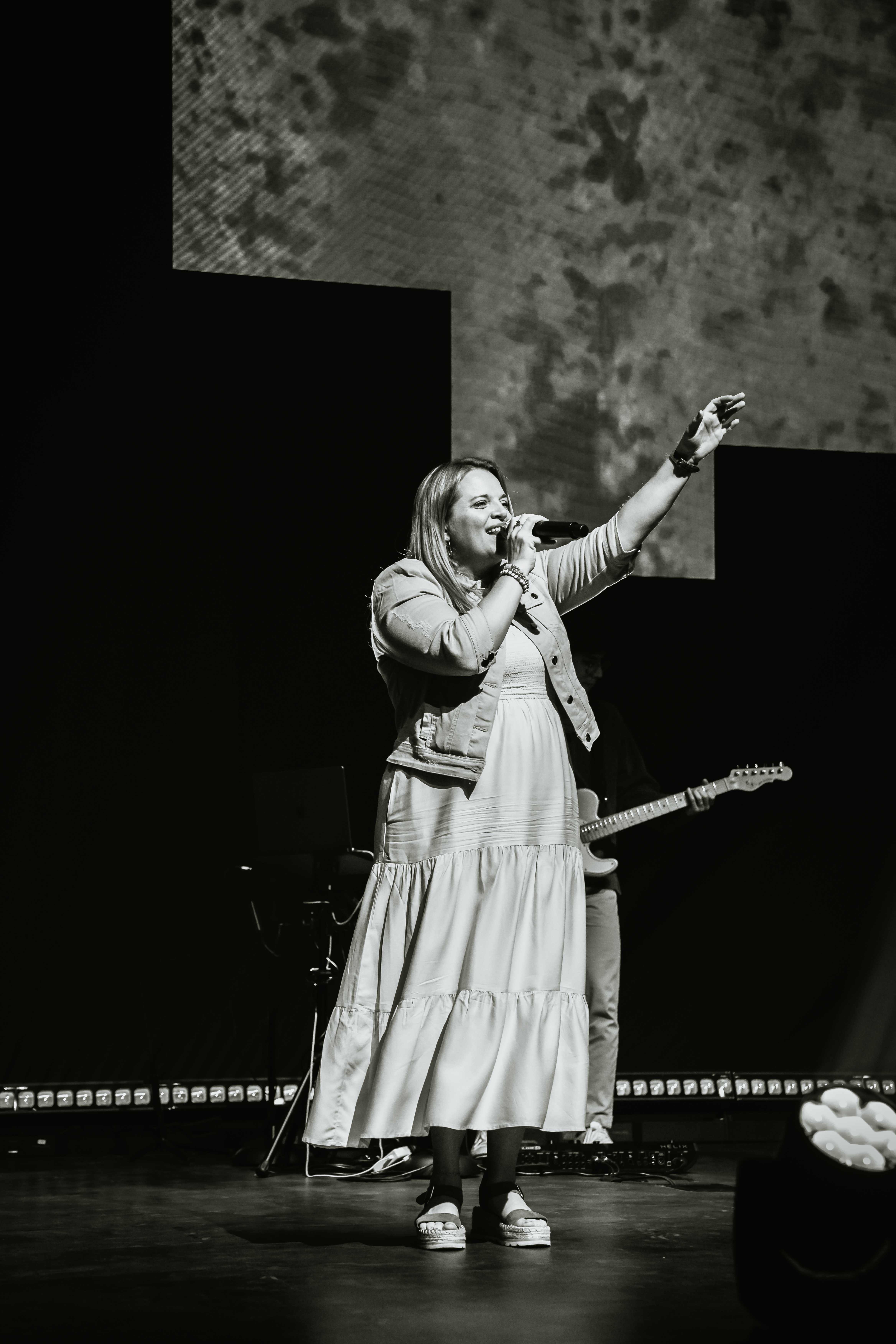Female worship singer performing on stage, black and white