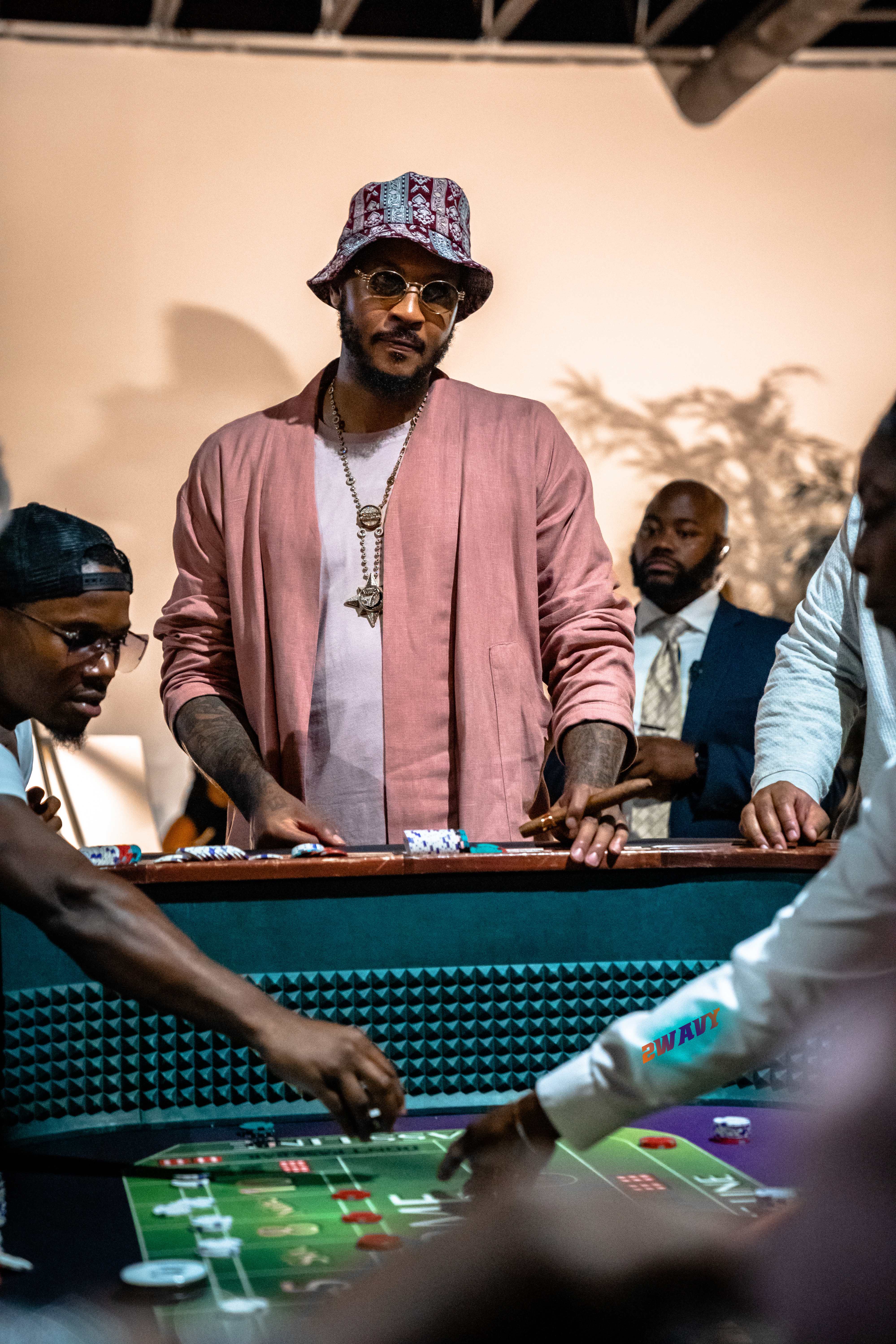 Carmelo Anthony at casino poker table in pink jacket