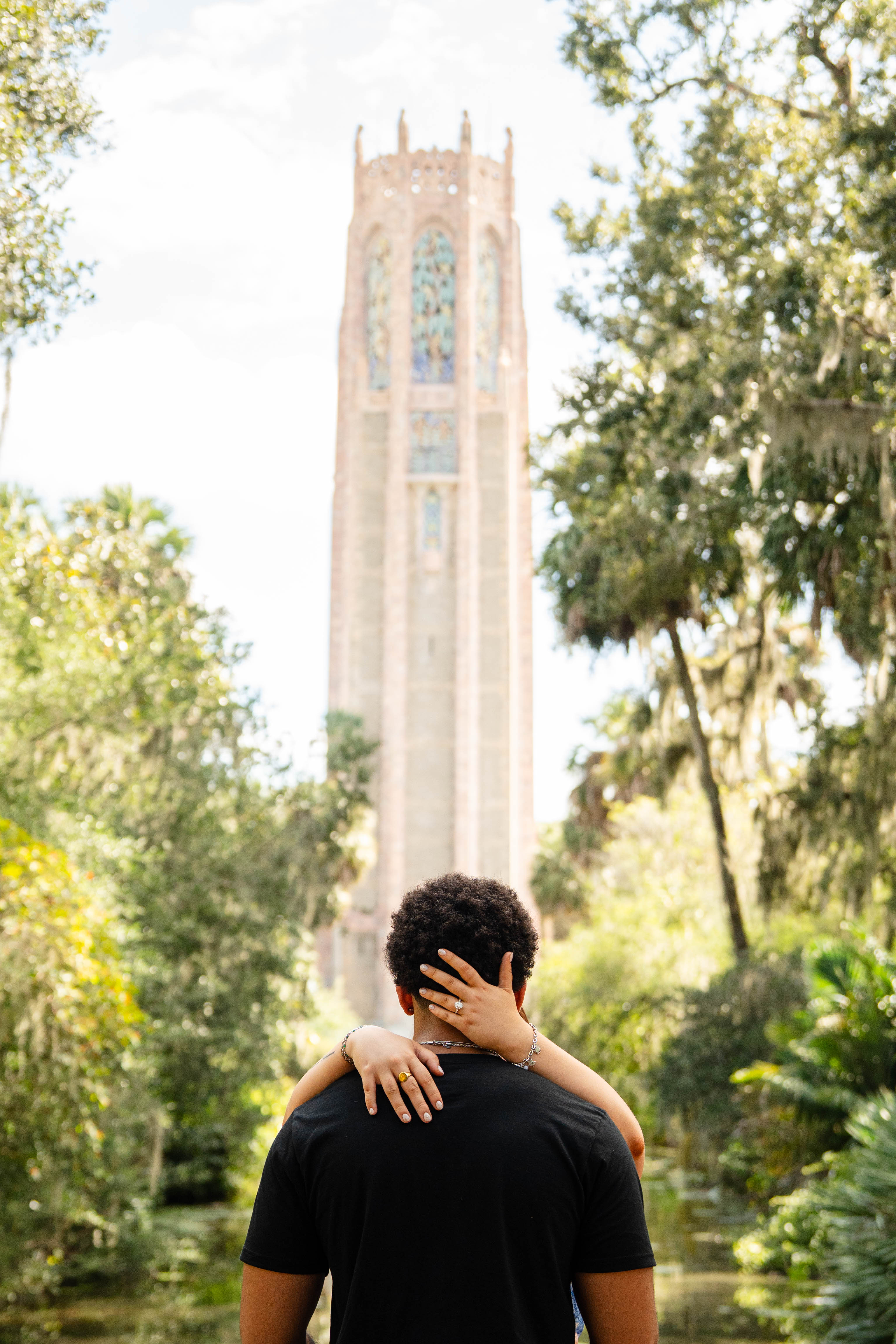 Couple embracing with Bok Tower Gardens in the background